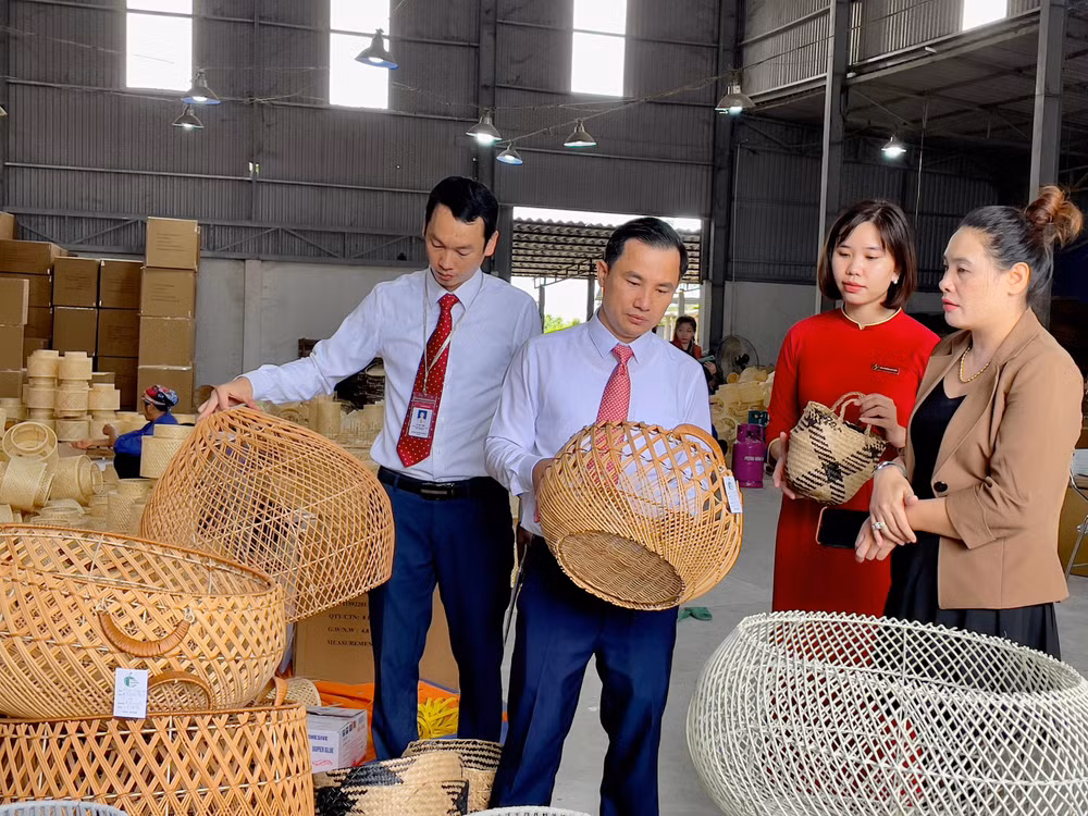 Bà Đặng Thị Dung (ngoài cùng bên phải) giới thiệu sản phẩm mây tre đan của doanh nghiệp với cán bộ Agribank.