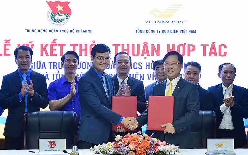 Hàng đầu, từ trái qua: các đồng chí Bùi Quang Huy, Ủy viên dự khuyết Trung ương Đảng, Bí thư thứ nhất Trung ương Đoàn; Chu Quang Hào, Tổng Giám đốc Tổng Công ty Bưu điện Việt Nam trao thỏa thuận hợp tác giữa 2 bên tại buổi lễ.