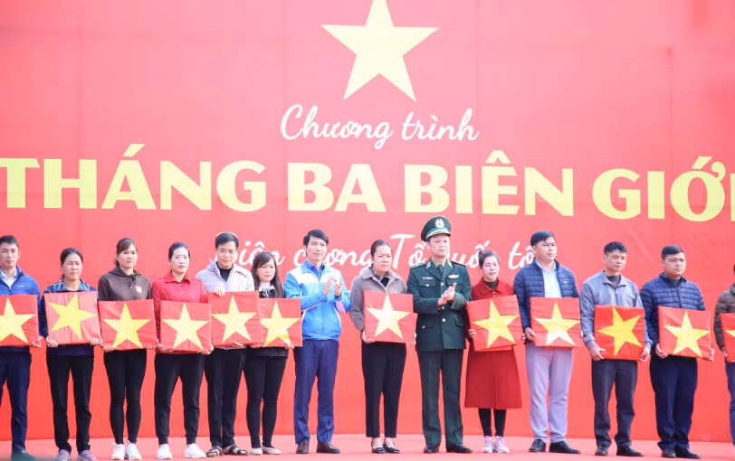 Đồng chí Nguyễn Ngọc Lương (thứ 7 từ trái sang) trao cờ Tổ quốc tặng đại diện người dân khu vực biên giới tại tỉnh Lạng Sơn.