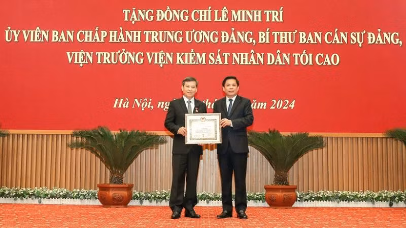 Đồng chí Nguyễn Văn Thể, Bí thư Đảng ủy Khối các Cơ quan Trung ương trao Huy hiệu 40 năm tuổi Đảng và tặng hoa chúc mừng đồng chí Lê Minh Trí, Viện trưởng Viện Kiểm sát nhân dân tối cao.