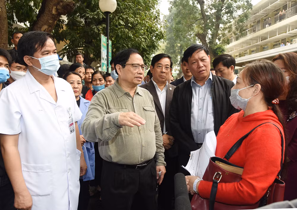 Thủ tướng trò chuyện với người nhà bệnh nhân về tình hình đáp ứng vật tư y tế và thuốc men tại Bệnh viện Bạch Mai.