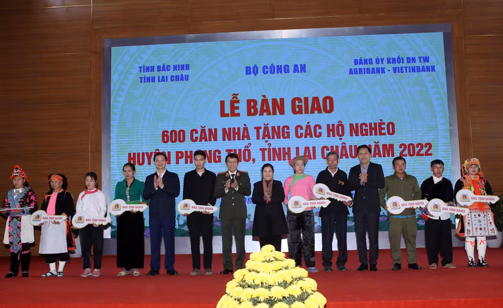 Lãnh đạo Bộ Công an, tỉnh Lai Châu và các nhà tài trợ trao tượng trưng chìa khóa cho các hộ nghèo.