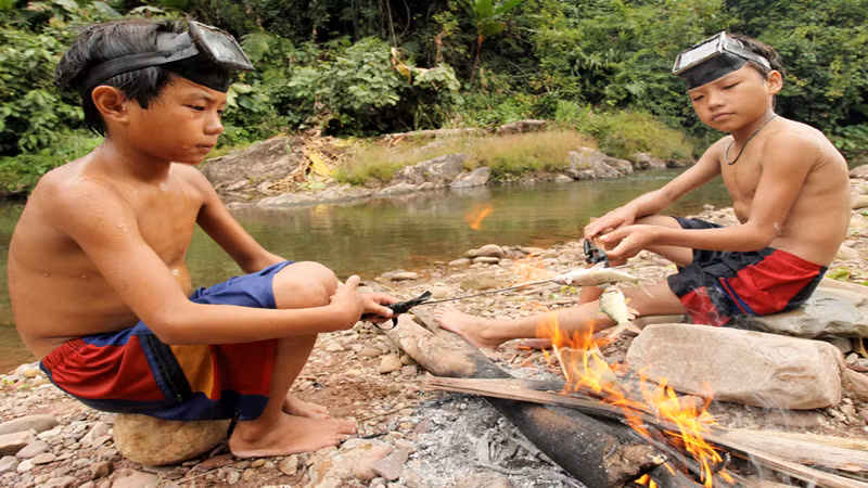 Học sinh đi lấy củi, đi bắt cá cải thiện bữa ăn sau giờ học cũng chẳng hiếm đối với những bản vùng khó cách đây hơn chục năm (Trong ảnh: Học sinh Trường Nậm Ngà, xã Tà Tổng bắt cá cải thiện cuộc sống sau giờ học).