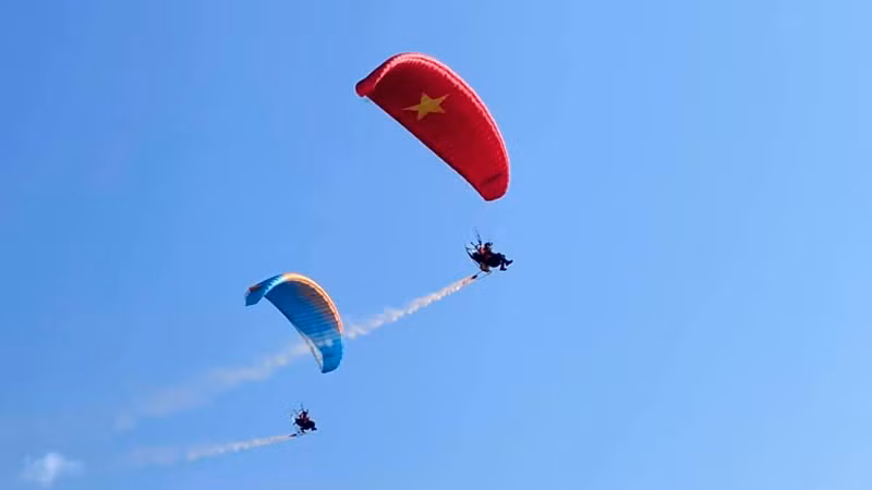 Các vận động viên bay trình diễn dù máy trước khi khai mạc giải.