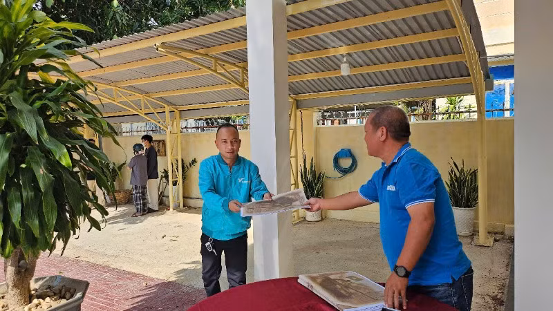 Bác tài xế tranh thủ ghé nhận ấn phẩm.