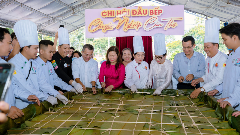 Lãnh đạo thành phố Cần Thơ cùng các nghệ nhân bên chiếc bánh chưng khổng lồ tại lễ hội.
