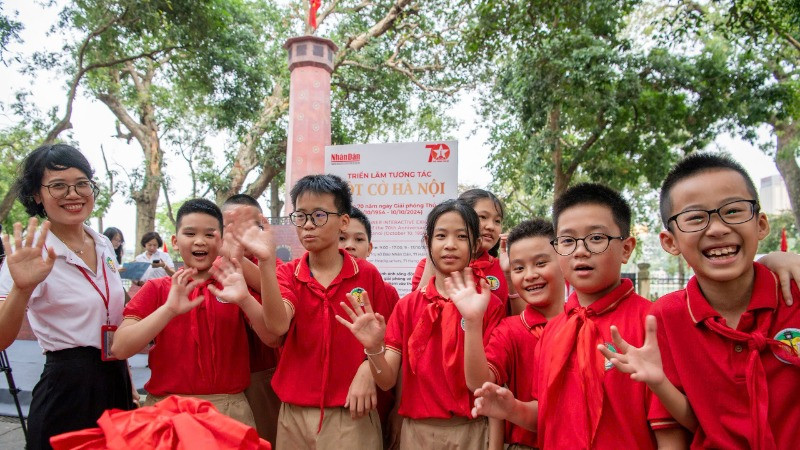 Các em học sinh Trường tiểu học Tràng An thích thú trước mô hình tái hiện Cột cờ Hà Nội. (Ảnh: THÀNH ĐẠT)