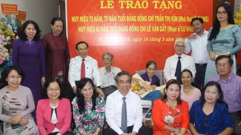 Đồng chí Nguyễn Văn Nên, Ủy viên Bộ Chính trị, Bí thư Thành ủy Thành phố Hồ Chí Minh và các đại biểu chụp hình lưu niệm với nhà thơ Lê Giang và nhạc sĩ Lư Nhất Vũ.
