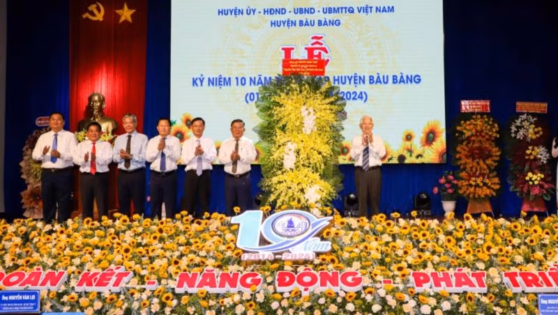 Nguyên Chủ tịch nước Nguyễn Minh Triết trao tặng lẵng hoa chúc mừng huyện Bàu Bàng. 