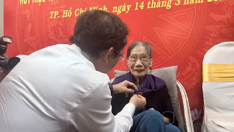 Đồng chí Nguyễn Văn Nên, Ủy viên Bộ Chính trị, Bí thư Thành ủy Thành phố Hồ Chí Minh gắn Huy hiệu Đảng tặng nhà thơ Lê Giang.