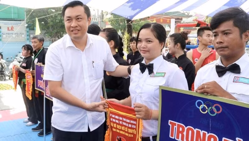 Ông Cao Văn Chóng, Phó Giám đốc Sở Văn hóa, Thể thao và Du lịch tỉnh Bình Dương, Trưởng ban Tổ chức giải tặng cờ lưu niệm cho tổ trọng tài và các đơn vị tham dự giải.