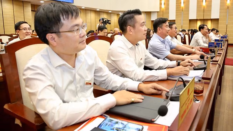 Các đại biểu biểu quyết thông qua nghị quyết. (Ảnh: DUY LINH)