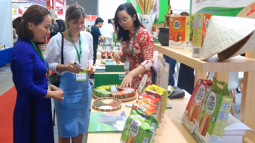 Khách tham quan, tìm hiểu sản phẩm tại một gian hàng thực phẩm tại Triển lãm.