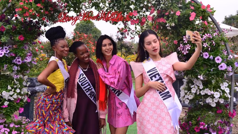 Các thí sinh dự thi Hoa hậu Du lịch Thế giới đang chụp ảnh check-in tại Festival Hoa Mê Linh.