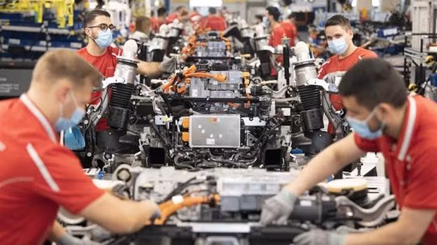 Công nhân làm việc trên dây chuyền lắp ráp xe ôtô của hãng Porsche ở Stuttgart, miền Nam Đức, ngày 12/5/2020. (Ảnh: AFP/TTXVN)