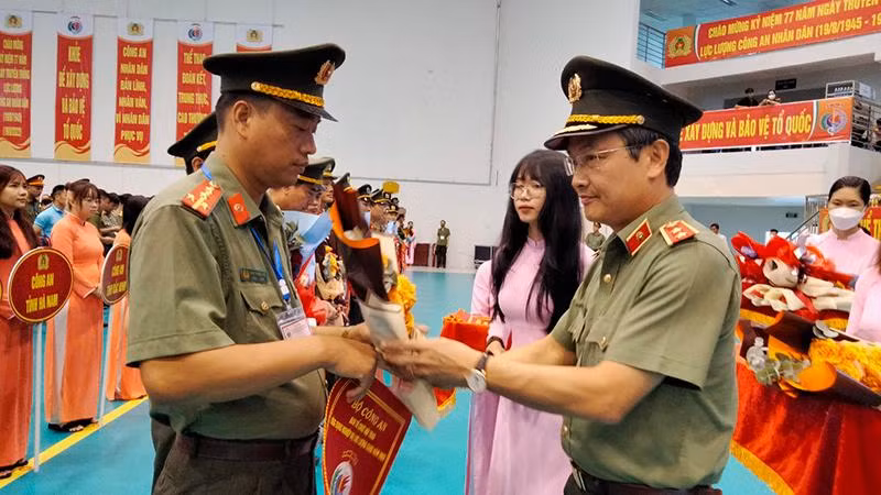 Trung tướng Nguyễn Ngọc Toàn (bên phải), Cục trưởng Cục Công tác Đảng và Công tác Chính trị Bộ Công an tặng hoa và cờ lưu niệm cho các đơn vị tham gia Hội thao ứng dụng nghiệp vụ lực lượng Công an nhân dân năm 2022.