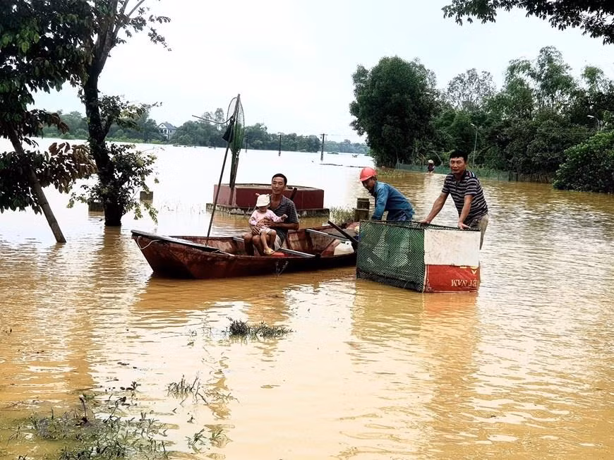 Hỗ trợ người dân di dời tới nơi an toàn. (Ảnh: Tá Chuyên/TTXVN)