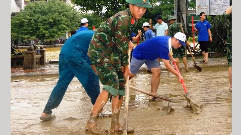 Lực lượng vũ trang tỉnh huy động cán bộ, chiến sĩ cùng thanh niên trong tỉnh dọn bùn, vệ sinh các tuyến đường tại thành phố Huế sau khi nước lũ rút ra.