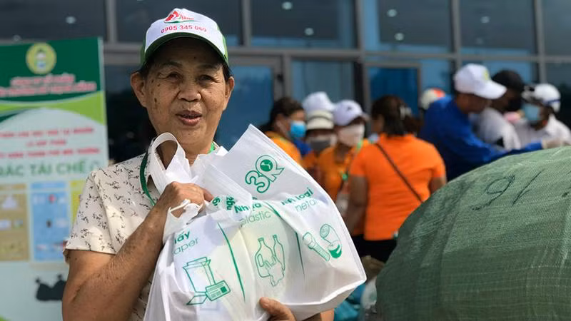 Niềm vui của một người dân sau khi tham gia chương trình đổi rác lấy quà tặng.