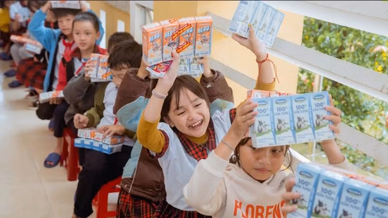 Các em học sinh tại Quảng Nam và Huế vui mừng khi nhận sữa Vinamilk từ đoàn hỗ trợ.