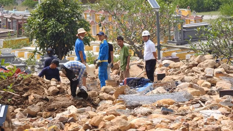 Người dân đào bới đất đá, tìm mộ người thân ở nghĩa trang Hòa Sơn.