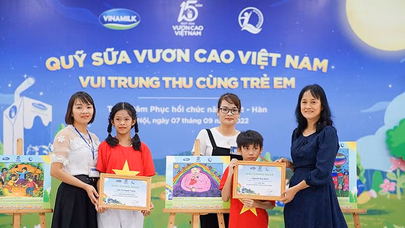 Em Phí Thị Huyền Trang (giải Khuyến khích) và Nguyễn Duy Mạnh (giải Ba) nhận quà từ đại diện Công ty Vinamilk.