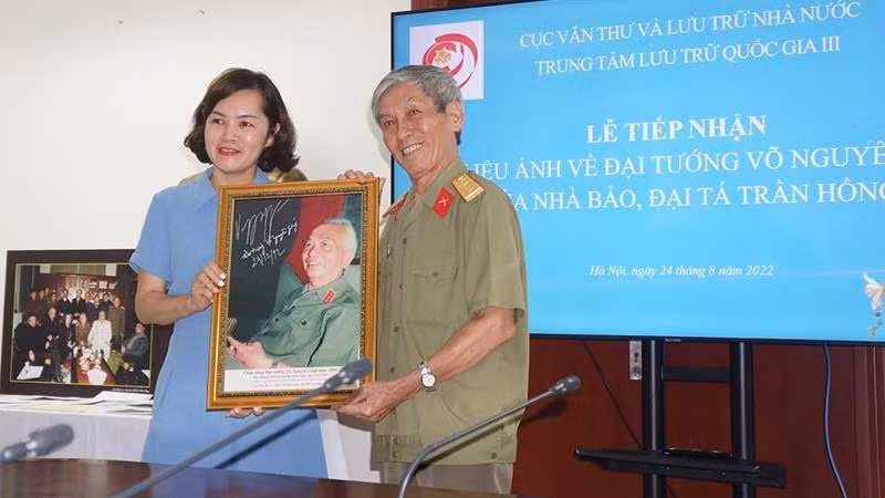 Bà Trần Việt Hoa - Giám đốc Trung tâm lưu trữ Quốc gia III tiếp nhận bức chân dung chụp Đại tướng Võ Nguyên Giáp từ Nhà báo, Đại tá Trần Hồng.