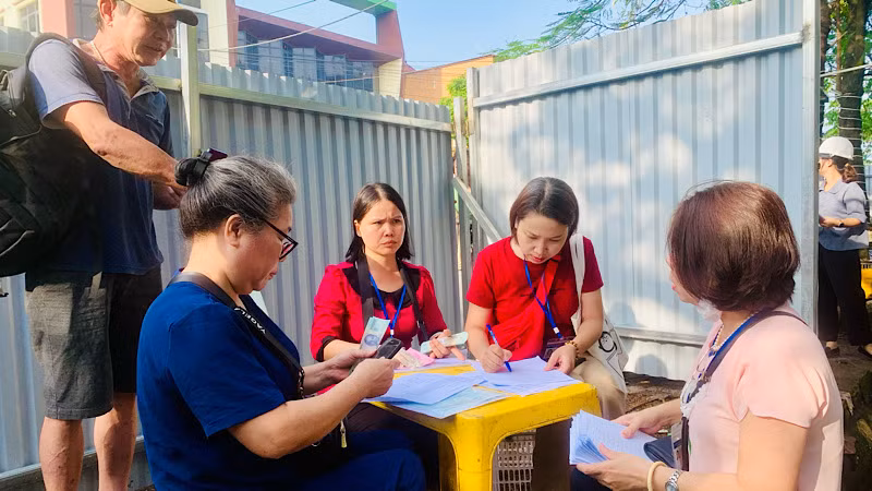 Các hộ dân xác nhận vị trí nhà ở cũ và nhận tiền hỗ trợ tự lo chỗ tạm cư.