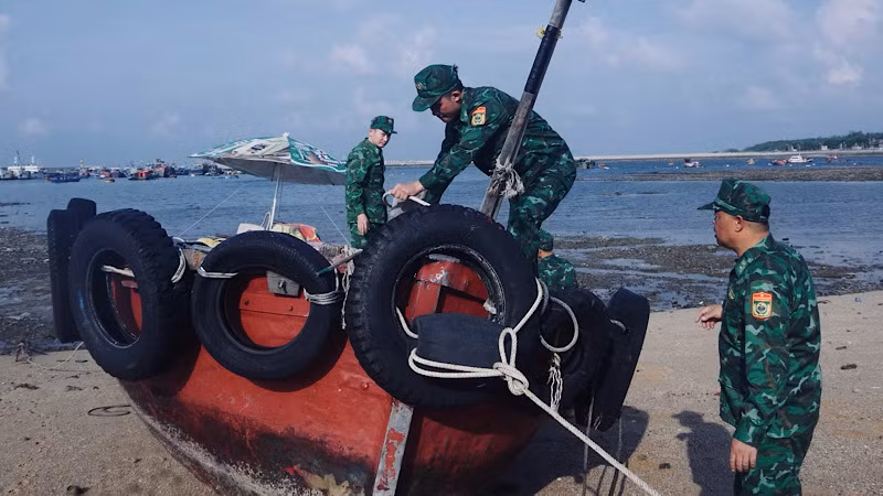 Biên phòng Bạch Long Vĩ giúp ngư dân chằng buộc tàu thuyền chống bão.