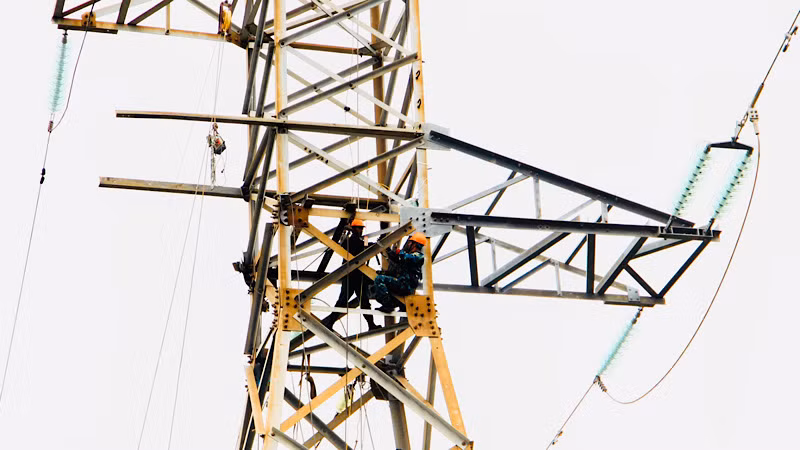 Công nhân Điện lực Hải Phòng làm việc trên cao trong thời tiết có mưa và gió lớn.