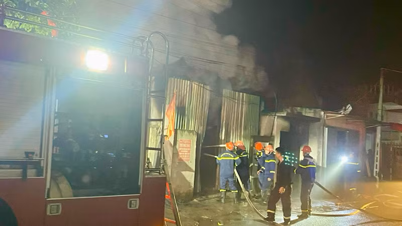 Các lực lượng chức năng phá cửa để chữa cháy.