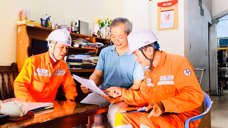 Nhân viên Công ty Điện lực Hải Phòng hướng dẫn khách hàng về điều chỉnh thời gian ghi chỉ số công-tơ điện hàng tháng.