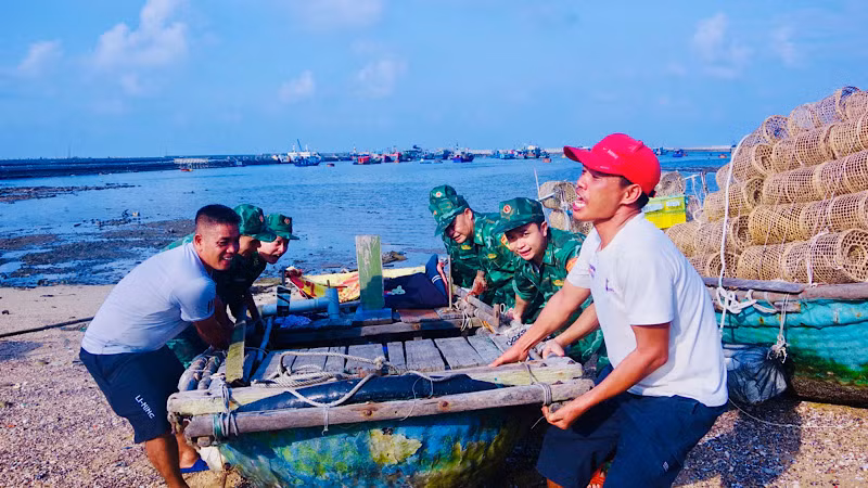 Cán bộ, chiến sĩ Đồn Biên phòng Bạch Long Vĩ giúp ngư dân đưa các phương tiện nhỏ lên bờ tránh trú bão số 3. (Ảnh: SƠN HÀ, Bộ đội Biên phòng Hải Phòng)