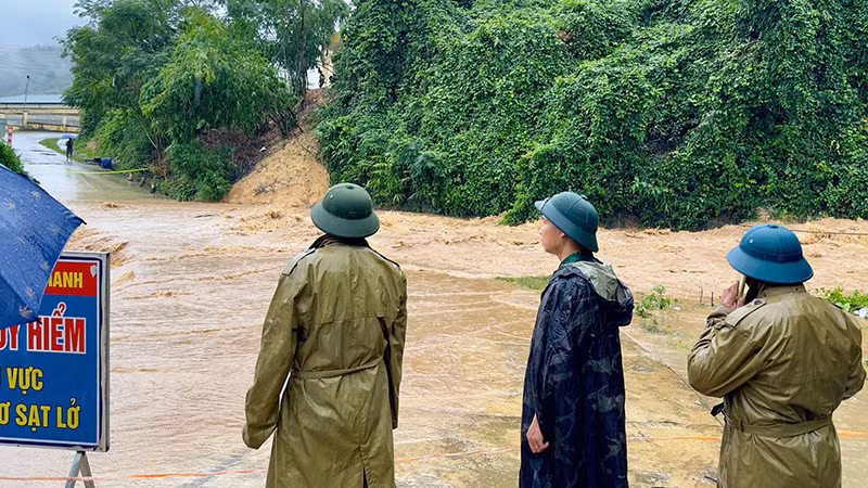 Lực lượng chức năng chặn, gác tại điểm đường giao thông ngập nước.