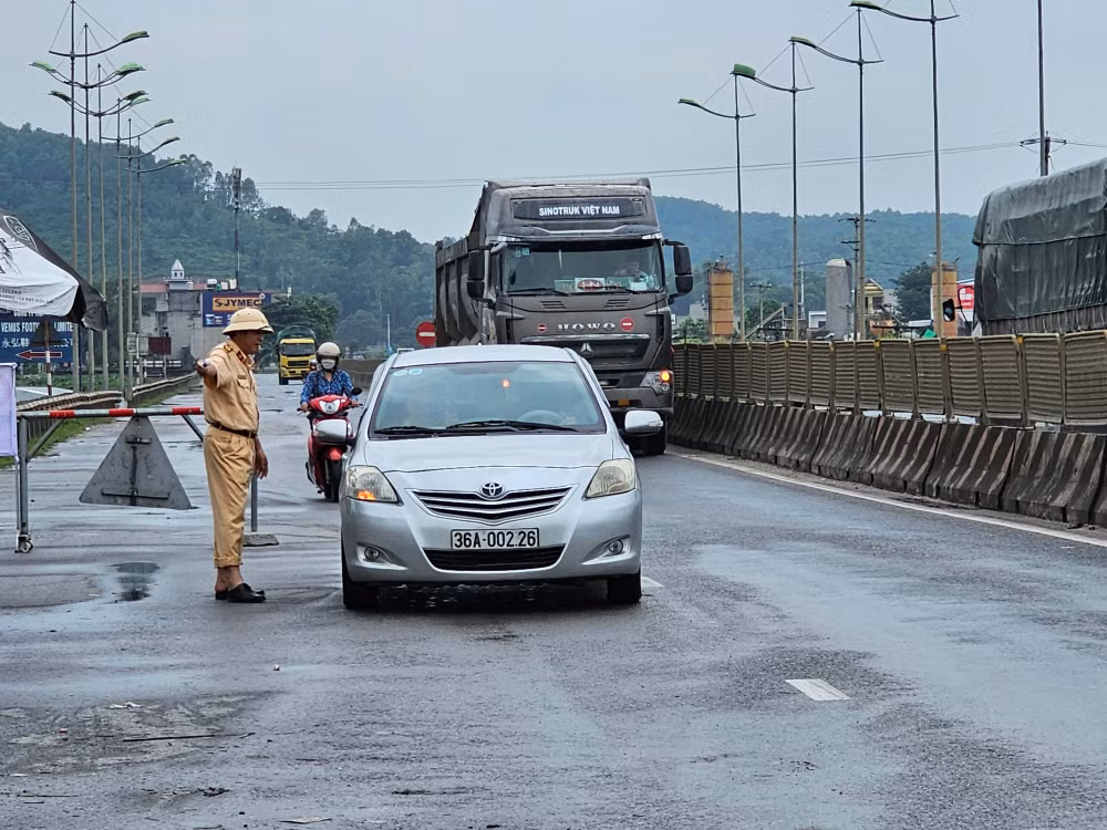 Cảnh sát điều tiết, hướng dẫn giao thông qua điểm ngập nước.