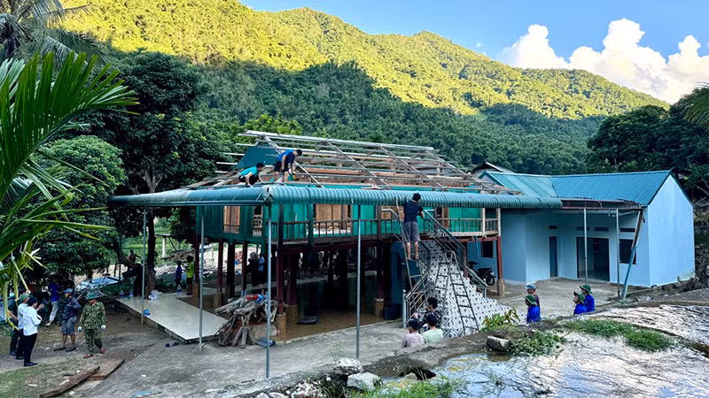 Lực lượng chức năng hỗ trợ hộ dân ở thị trấn Mường Lát tháo dỡ nhà ở, di chuyển đến nơi an toàn.