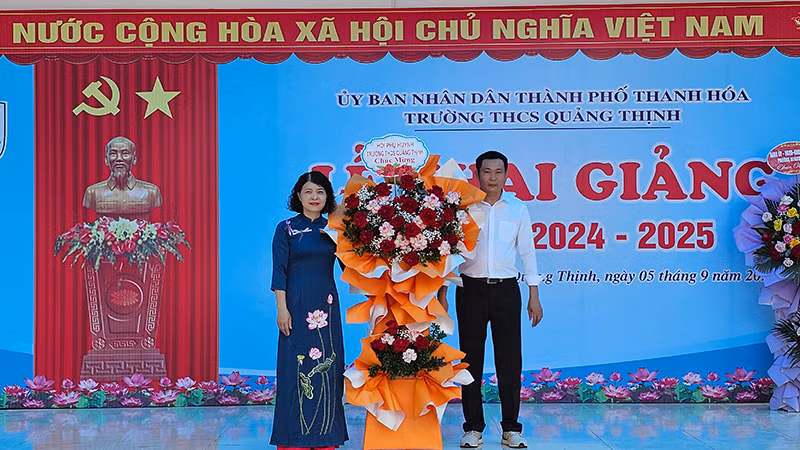 Đại diện hội phụ huynh tặng hoa chúc mừng cơ sở giáo dục.