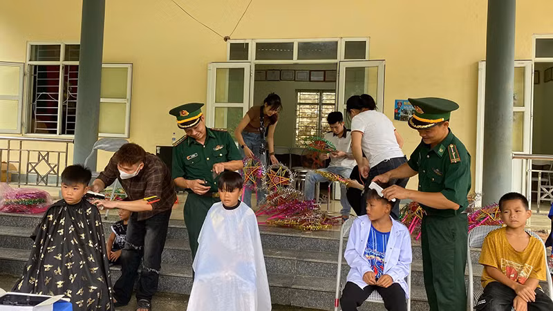 Bộ đội Biên phòng cắt tóc cho trẻ em.