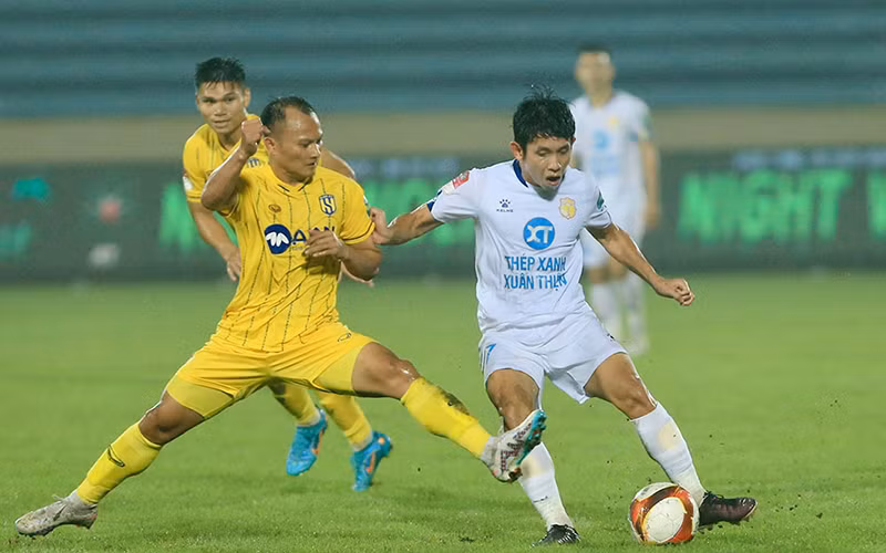 Pha tranh bóng giữa cầu thủ hai đội Thép Xanh Nam Định (áo trắng) và Sông Lam Nghệ An. (Ảnh VPF)