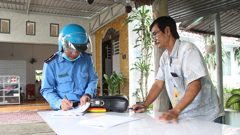Lực lượng chức năng lập biên bản cam kết tháo dỡ công trình vi phạm hành lang bảo vệ cầu Tầm Vu trên quốc lộ 61.
