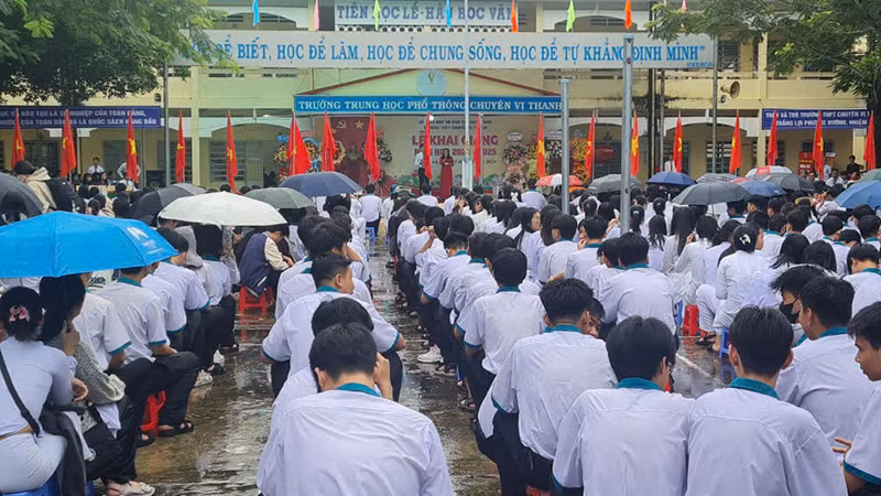 Các em học sinh đội mưa dự lễ khai giảng.