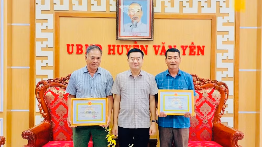 Đại diện Ủy ban nhân dân huyện Văn Yên khen thưởng 2 công dân dũng cảm cứu trẻ em khỏi đuối nước. (Ảnh: THANH SƠN)