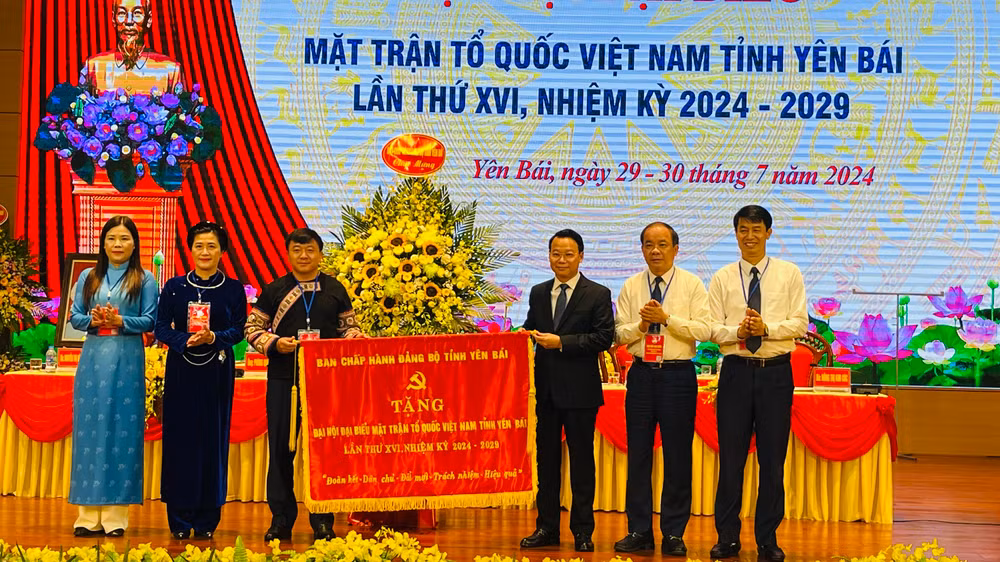 Đồng chí Đỗ Đức Duy, Ủy viên Trung ương Đảng, Bí thư Tỉnh ủy Yên Bái tặng bức cờ thêu tại đại hội. (Ảnh: THANH SƠN)