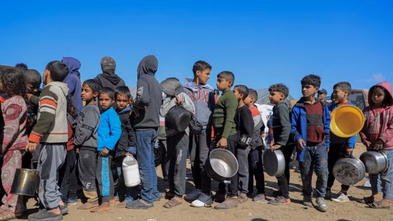 Người dân xếp hàng chờ được phát thực phẩm cứu trợ tại Rafah, Dải Gaza. (Ảnh: THX/TTXVN)