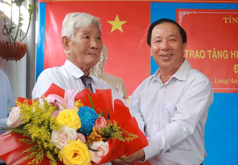 Đồng chí Nguyễn Văn Út, Phó Bí thư Tỉnh ủy, Chủ tịch Ủy ban nhân dân tỉnh Long An trao Huy hiệu 65 tuổi Đảng cho đồng chí Đặng Văn Bầu tại nhà riêng.