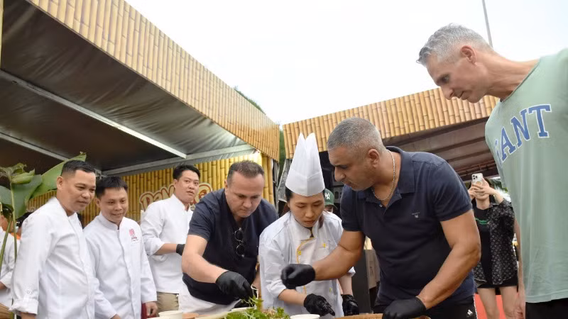 Du khách quốc tế trải nghiệm làm gỏi cá tại Lễ hội Đà Nẵng Food Tour 2025.