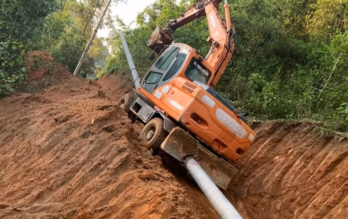 Mở đường "cõng" cột điện, vật tư vào điểm thi công hệ thống điện.