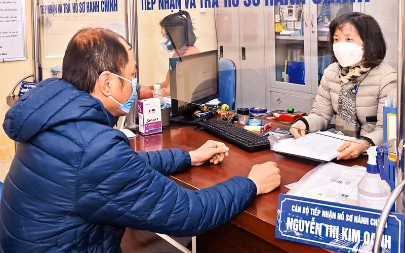 Cán bộ tại Bộ phận “một cửa” UBND phường Nguyễn Du, quận Hai Bà Trưng, giải quyết thủ tục hành chính cho người dân. (Ảnh: Đăng Duy) 