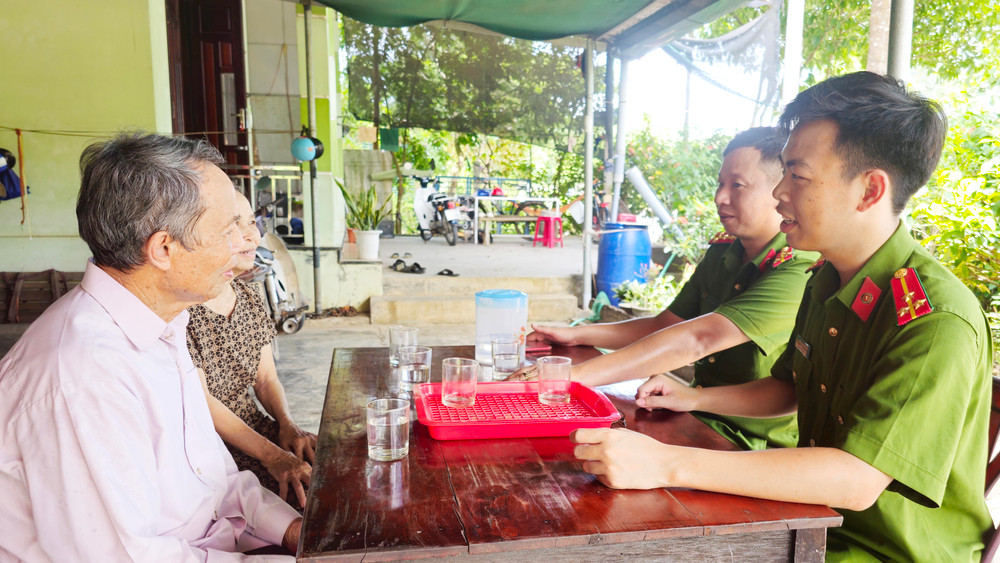 Thượng úy Nguyễn Đăng Thiện cùng đồng đội trao đổi với ông Lê Dục về kết quả mô hình phòng ngừa, giáo dục người chưa thành niên vi phạm pháp luật. 