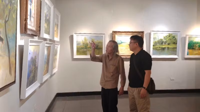 Họa sĩ Lương Xuân Đoàn, Chủ tịch Hội Mỹ thuật Việt Nam (bên trái) tham quan triển lãm.